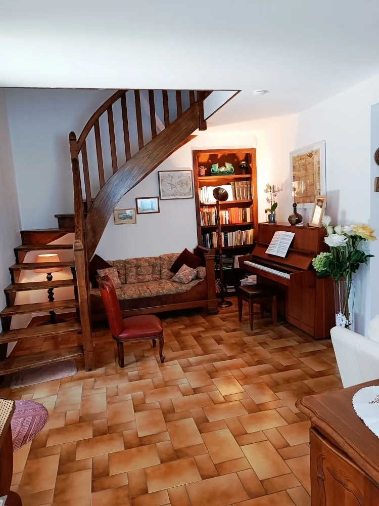 Bibliothèque et piano près de l’escalier